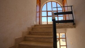 A staircase leading to a balcony with a view of a desert landscape.