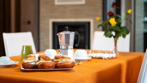 A table with pastries, a coffee pot, and a vase with flowers. - Apartment 'Luna Piena' with Sea View, Wi-Fi and Air Conditioning (Tusa)