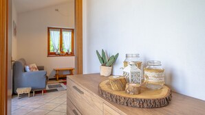 A living room with a sofa, a small table, and decorative jars on a wooden tray. - Holiday Home 'La Rosa Bianca' with Mountain View, Private Terrace and Wi-Fi (Morbegno)