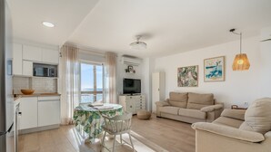 Un soggiorno moderno con cucina, zona pranzo e angolo salotto.