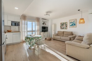 A modern living space with a kitchen, dining area, and seating area.