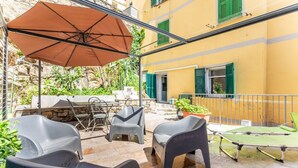 Eine Terrasse mit Gartenmöbeln, einem Tisch und einem Tischtennisschläger.