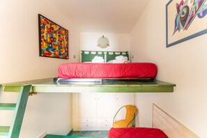 A bunk bed with a green frame, a red mattress, and a chair with a yellow seat. - Charming 50 sqm apartment in the center of Riomaggiore, with a large equipped terrace. It is located on the second floor of a 2-storey building (10 steps to access, NO elevator).The apartment is located in a central area, close to all services, the sea a (Riomaggiore)