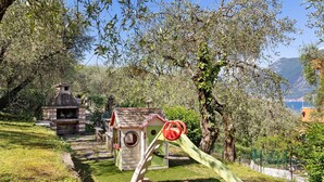 A playground with a slide, a small playhouse, and a brick oven. - Apartment 'Panorama' with Lake View, Wi-Fi and Air Conditioning (Brenzone sul Garda)