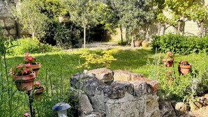 A garden with potted plants, a stone wall, and a lantern. - Abbaye Cottage
Charming House in the Heart of Fontevraud-Private Garden-Jacuzzi (Fontevraud-l'Abbaye)