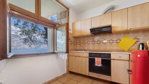 Una cocina con armarios de madera, una estufa y una ventana con vistas panorámicas.