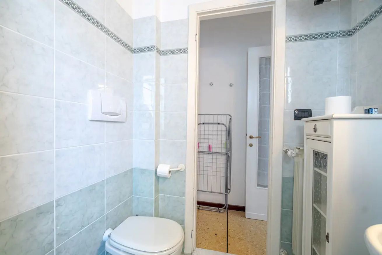A bathroom with a toilet, a shower, and a sink.