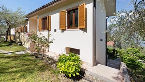 A two-story house with a white exterior, wooden shutters, and a small front porch.