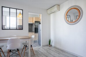A modern kitchen with wooden cabinets, a built-in oven, and a white refrigerator. - Cocooning – Your Peaceful Haven Just 10 Minutes’ Walk from Fréjus Beaches (Fréjus)