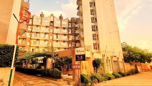 Un edificio residenziale a più piani con balconi, un'area reception e un cartello.