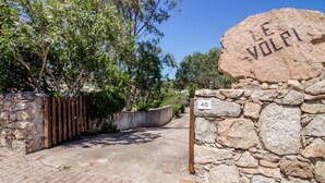 Un muro de piedra con un letrero que dice 'LE VOLPI' y el número 46.