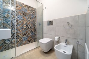 Een douche, een haardroger, een bidet, handdoeken