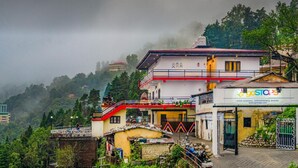 A building with a sign reading "goSTOPS" and a staircase leading to a balcony. - goSTOPS Mussoorie Library Road (Mussoorie)
