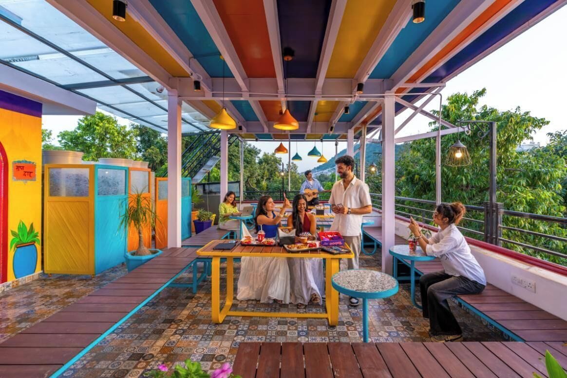 Un espacio de comedor al aire libre con paredes de colores, una zona de estar cubierta y vistas a zonas verdes.