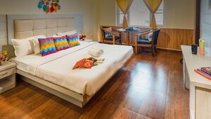 A hotel room with a bed, bedside tables, a desk, and a chair. - goSTOPS Mussoorie Library Road (Mussoorie)
