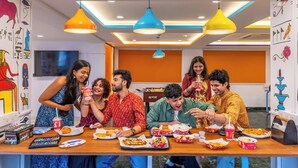 A group of people dining at a table with various food items and drinks. - goSTOPS Mussoorie Library Road (Mussoorie)