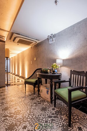 A hotel lobby with patterned flooring, a reception desk, and a seating area with chairs and a table. -  Royal Signature Hotel Hanoi (Hanoi)