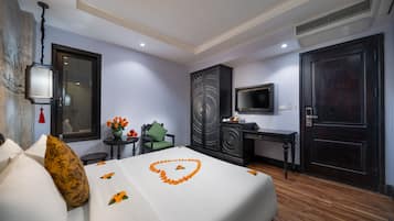 A hotel room with a bed, a desk, a TV, and a wardrobe.