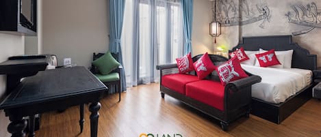 Una habitación de hotel con cama, sofá, mesa y escritorio.