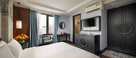 Una camera d'albergo con un letto, una scrivania, una televisione e un condizionatore.