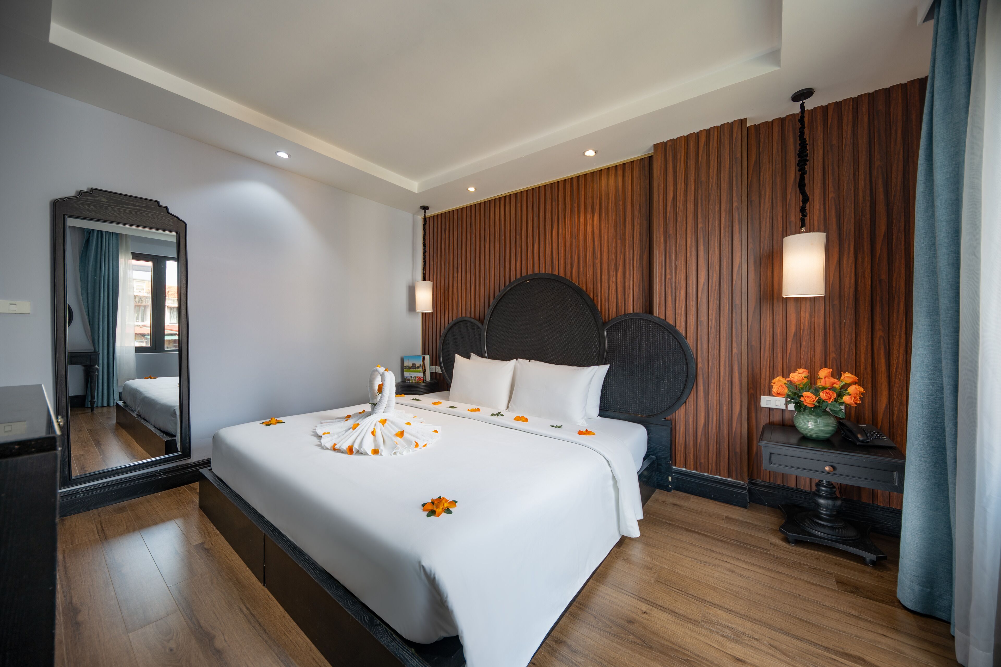Ein Hotelzimmer mit einem großen Bett, einer Wand aus Holzpaneelen und einem Spiegel.