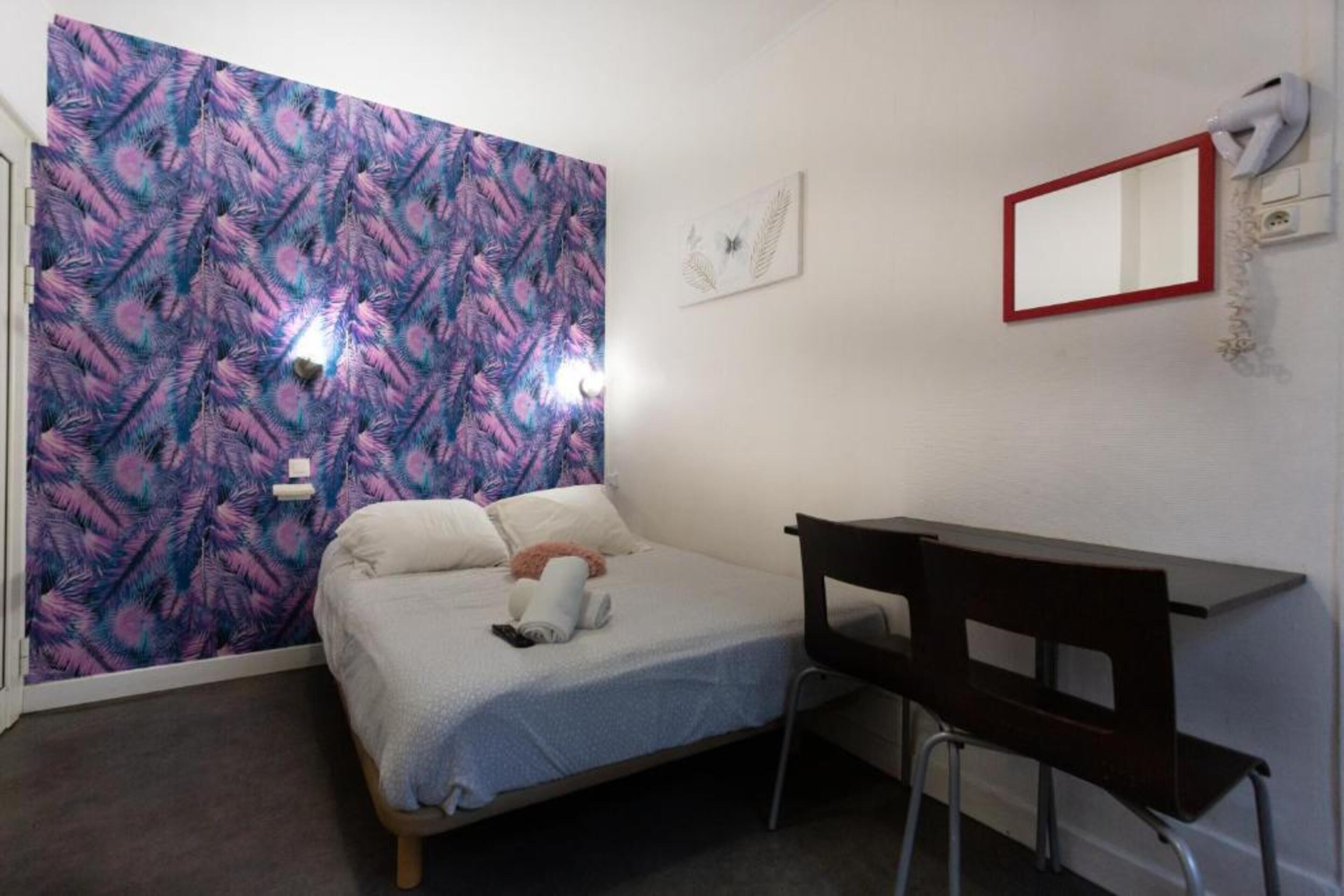Una habitación pequeña y ordenada con una cama, un escritorio y una silla.