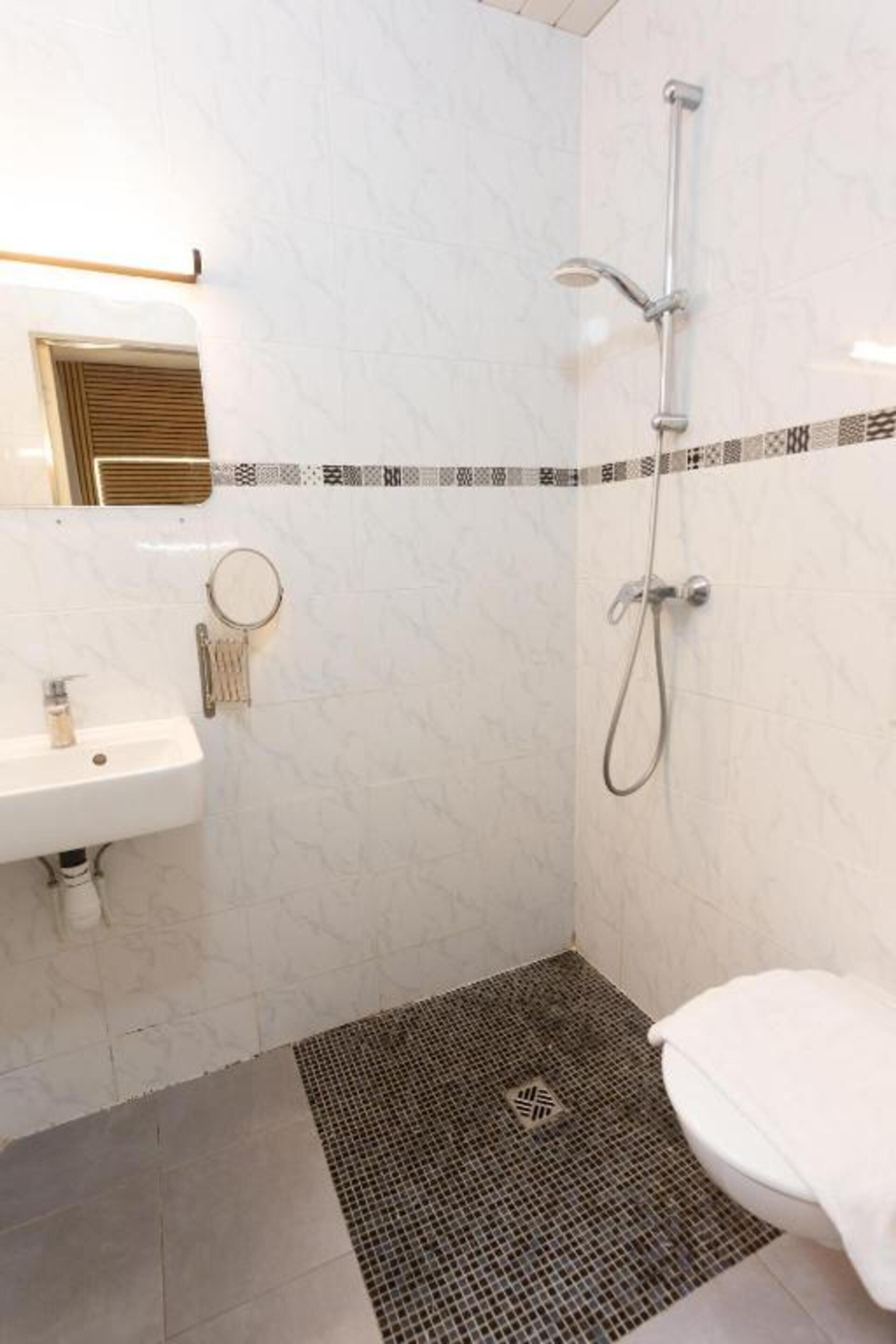 Une salle de bain avec une douche, un lavabo et des toilettes.