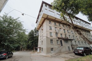 A multi-story building with a flat roof, several windows, and a staircase leading to the entrance. - Rîșcani Open-Plan Apartment by the Park (Chișinău)