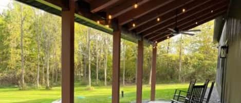 Relax under the stars in this serene outdoor space, complete with a ceiling fan and string lights.