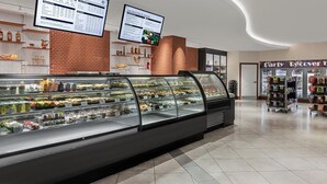 Eine Bäckereiauslage mit verschiedenen Backwaren und einer Speisekarte darüber.