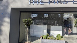 A modern building with a reception desk and a sign that reads "THE FRS L". - OYO Firs Lodge London Heathrow| Standard Single (Hounslow)