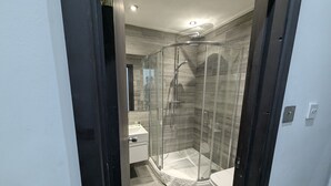 A modern bathroom with a glass-enclosed shower, a white sink, and a toilet. - OYO Firs Lodge London Heathrow| Standard Double (Hounslow)