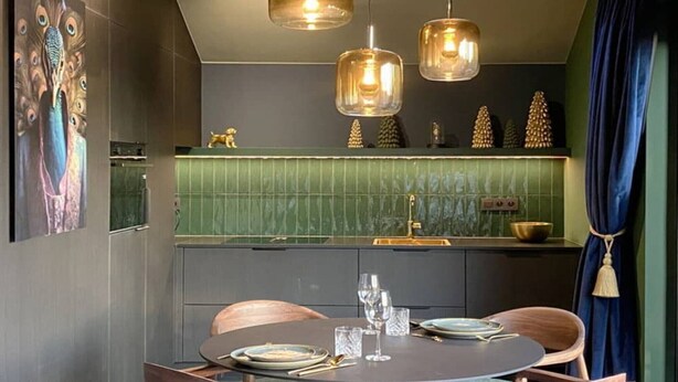 A modern dining area with a round table, chairs, and pendant lighting.