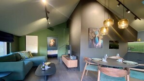 A modern interior with a dining area, a sofa, and a kitchen.
