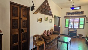 Une pièce de style traditionnel, avec des portes en bois, un canapé, une table et un élément décoratif mural.