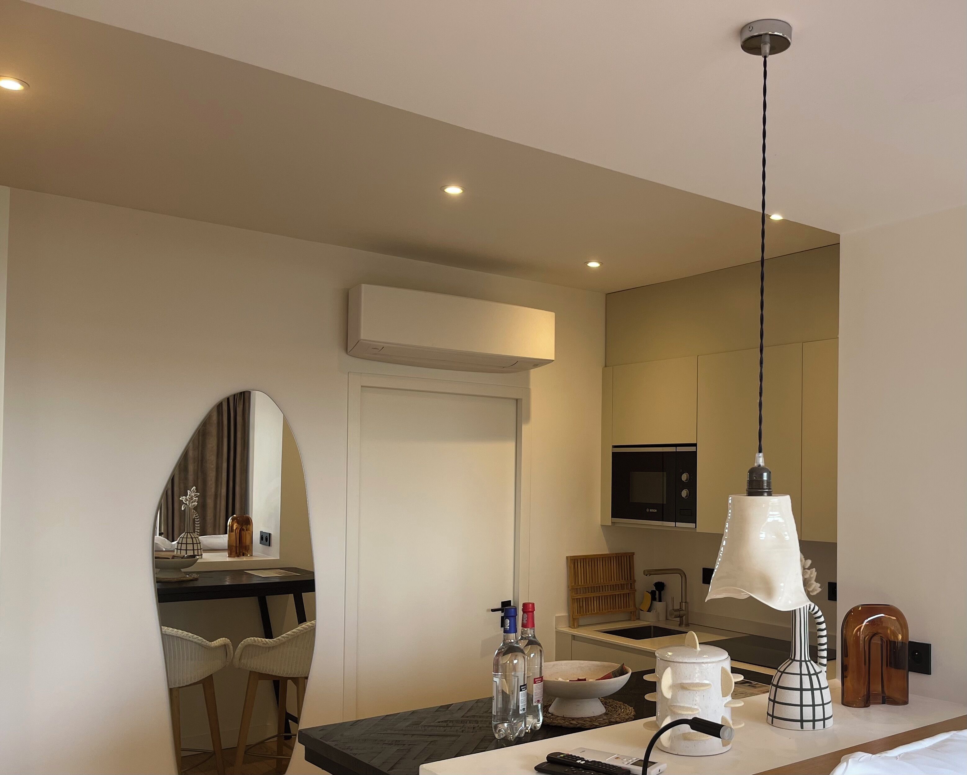 A modern kitchen with a microwave, a sink, and a dining area with chairs.