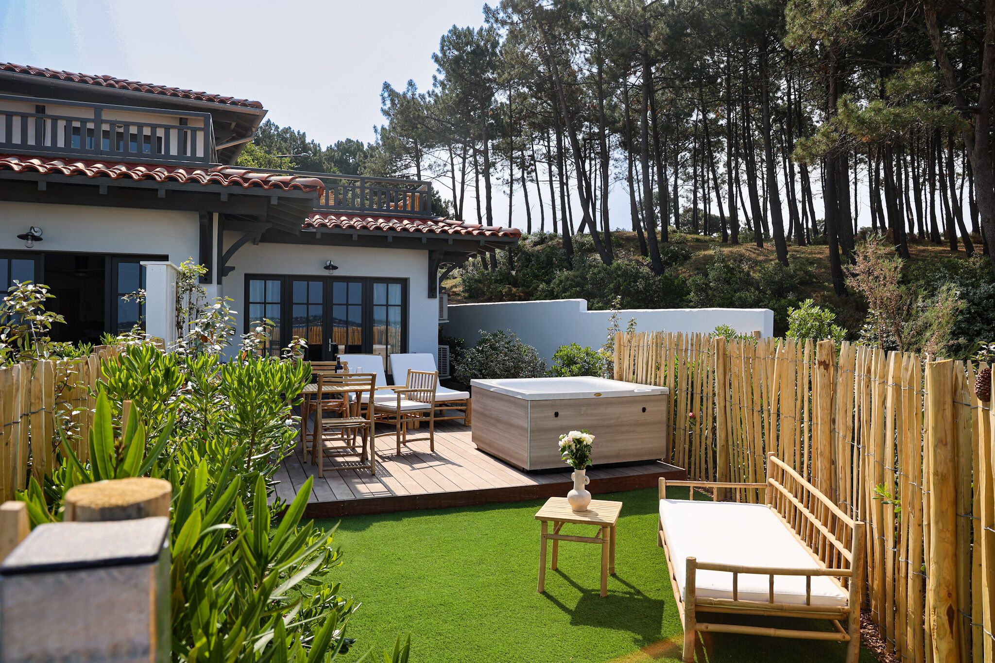 A modern house with a patio, outdoor seating, and a hot tub.