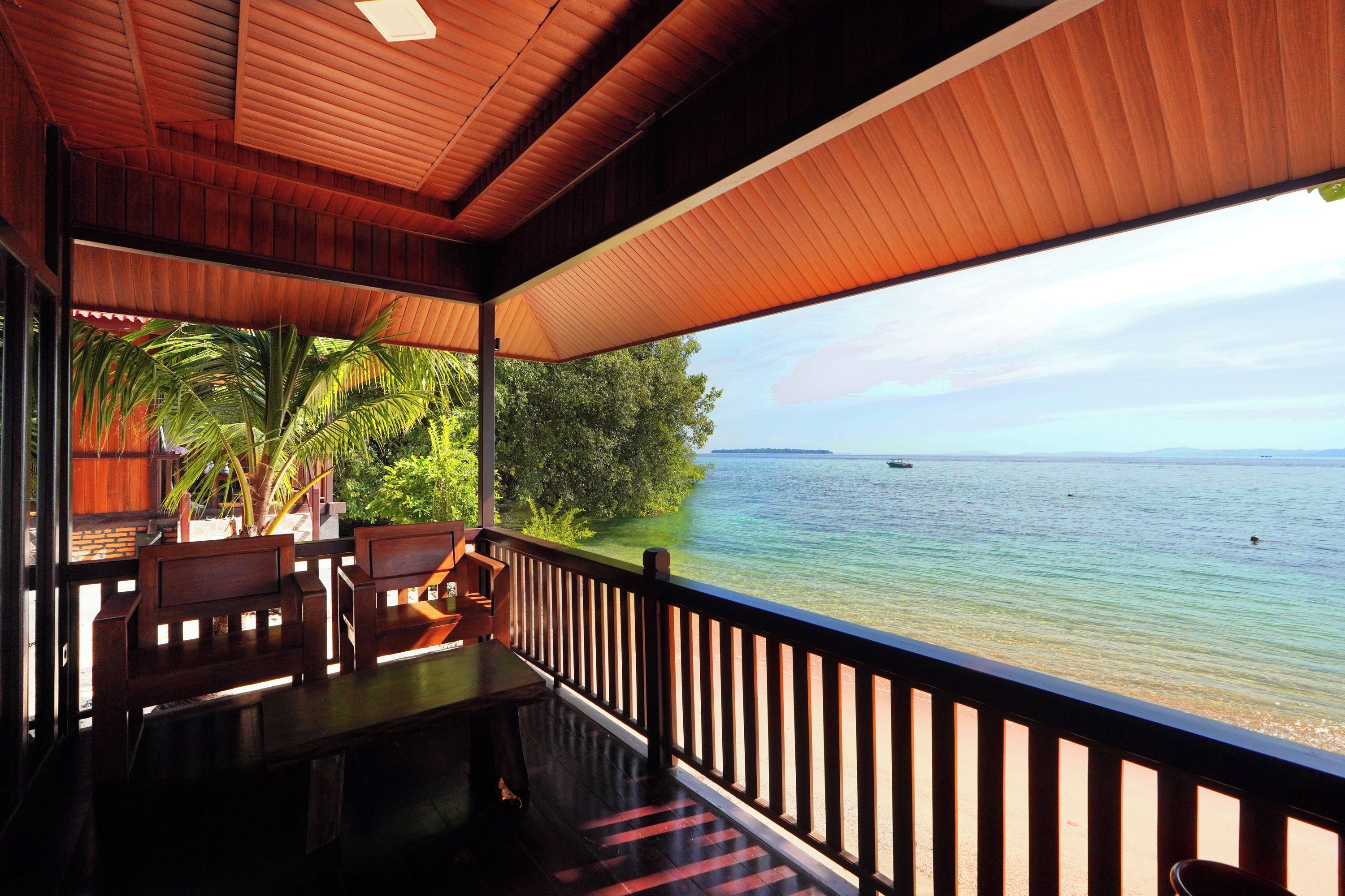 A wooden deck with a view of the sea and a distant island.