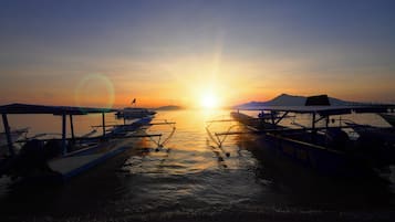 A sunset over a body of water with boats docked.