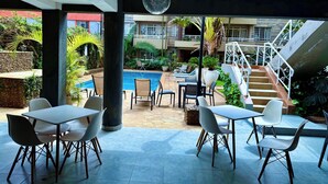 A poolside area with outdoor seating and a staircase leading to an upper level. - Eldon Hotel & Apartments (Nairobi)