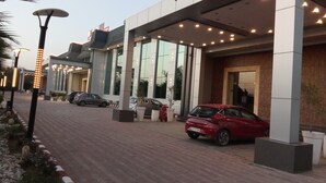 Un bâtiment moderne doté d’un porche, d’un espace de stationnement et de réverbères décoratifs.