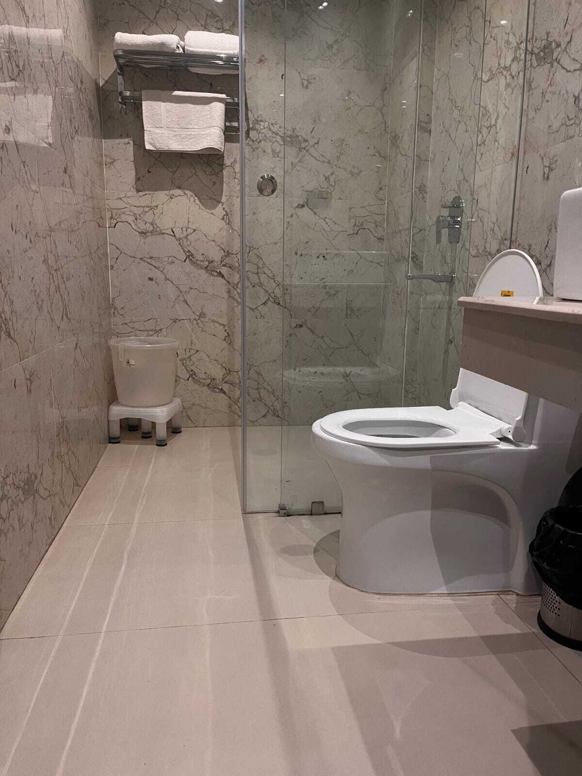Une salle de bain comprenant des toilettes, un espace douche et un lavabo.
