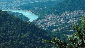 A panoramic view of a coastal city with a river, dense urban area, and surrounding hills. - Kailasham Homestay (Kyarki)