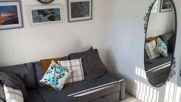 Apartment, 1 Bedroom, Garden View | Living room | Flat-screen TV, books