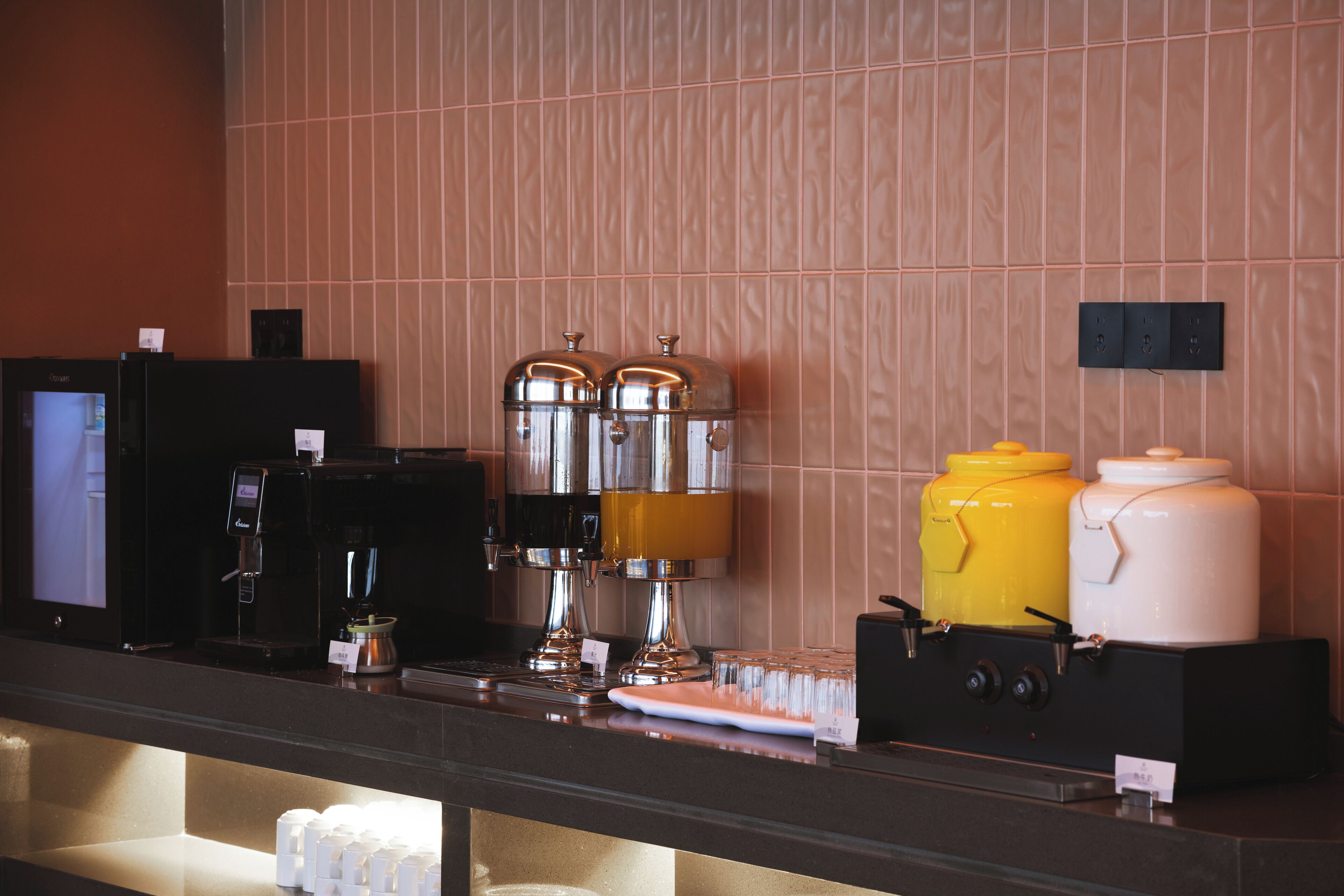A coffee station with a coffee machine, two dispensers, and a coffee pot.