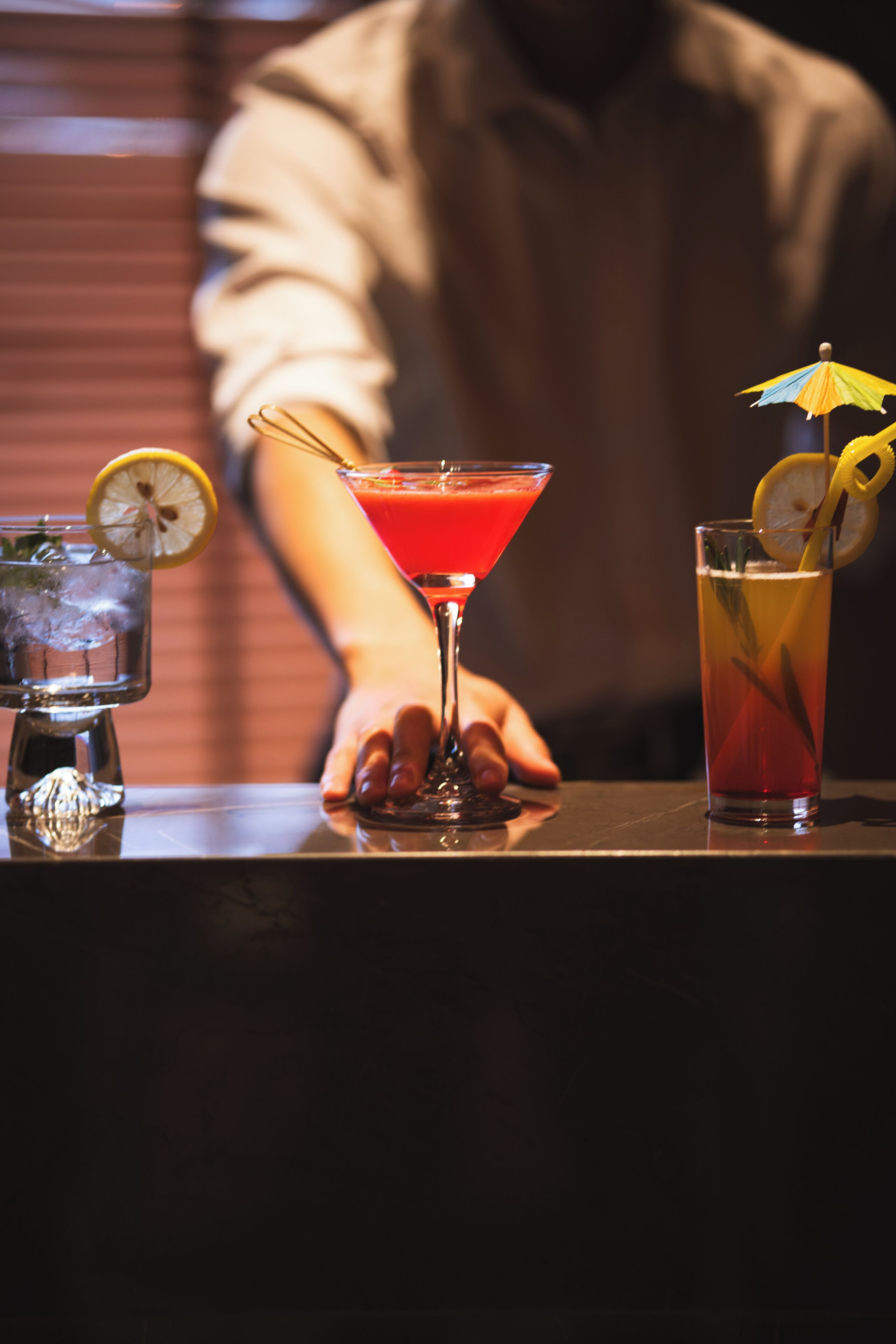 Un bar con tres bebidas sobre una barra.