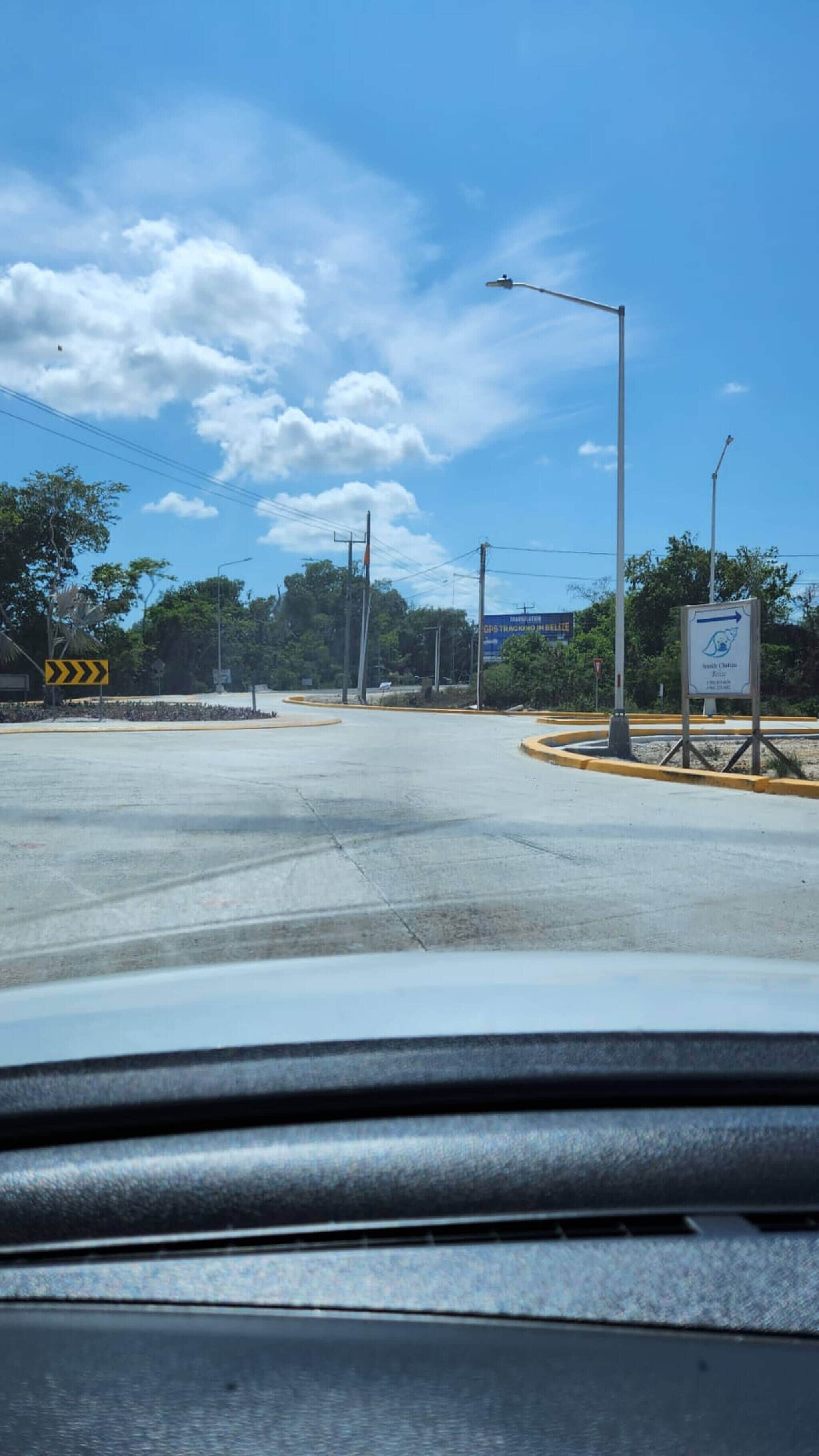 A road intersection with a clear sky, street signs, and a traffic light.