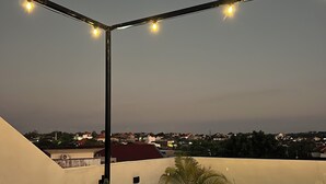 A rooftop terrace with string lights, a cactus plant, and bean bags. - Nusa Dua 3BR Villa • Perfect for Families (Bali)