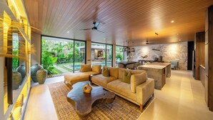 Uma sala de estar moderna com teto de madeira, janelas amplas e vista para um jardim.