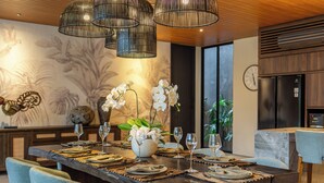 Uma sala de jantar moderna com uma mesa comprida posta para seis pessoas, rodeada de cadeiras.